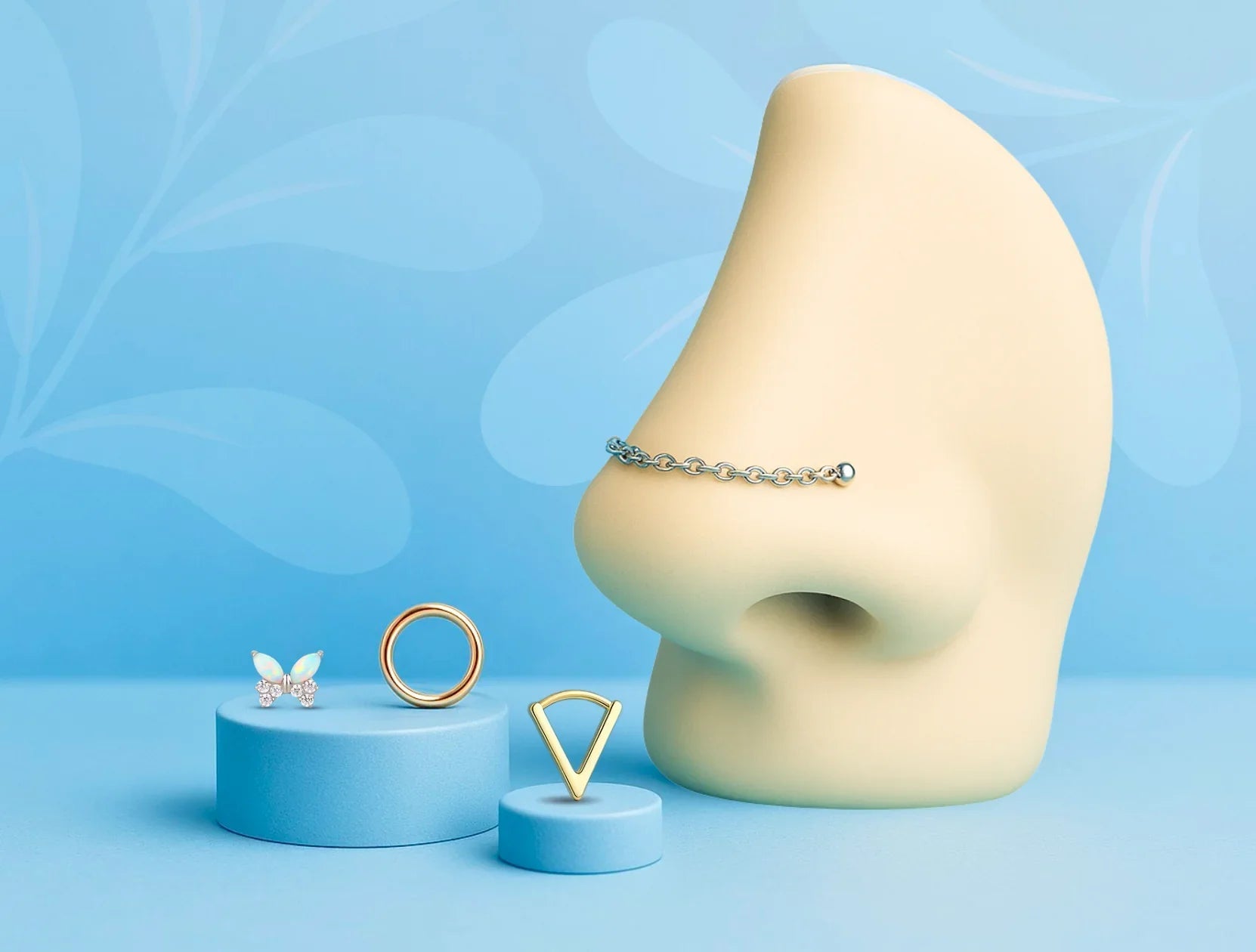 Nez stylisé avec chaîne reliant deux piercings de narine, et trois bijoux de nez (papillon, anneau, triangle) posés sur des socles bleus.